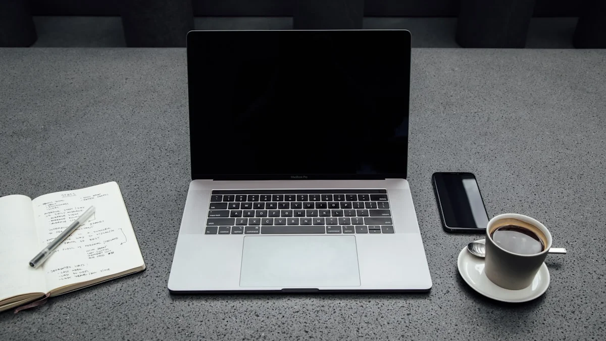 An open laptop with a dark screen beside a handwritten notebook, a face-down phone, and a cooling cup of coffee on a grey table - a Quiet Core Reset guide to Social Comparison Explained Simply.