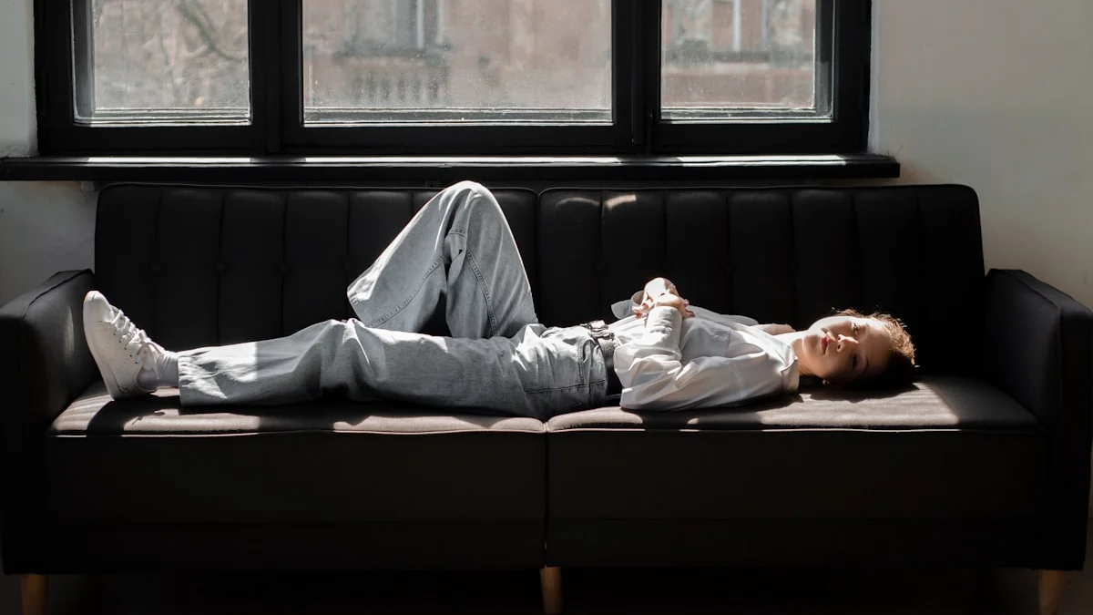 A person lying flat on a sofa in a shaft of afternoon light, completely drained - a Quiet Core Reset guide to Why You're Tired Without Doing Much.