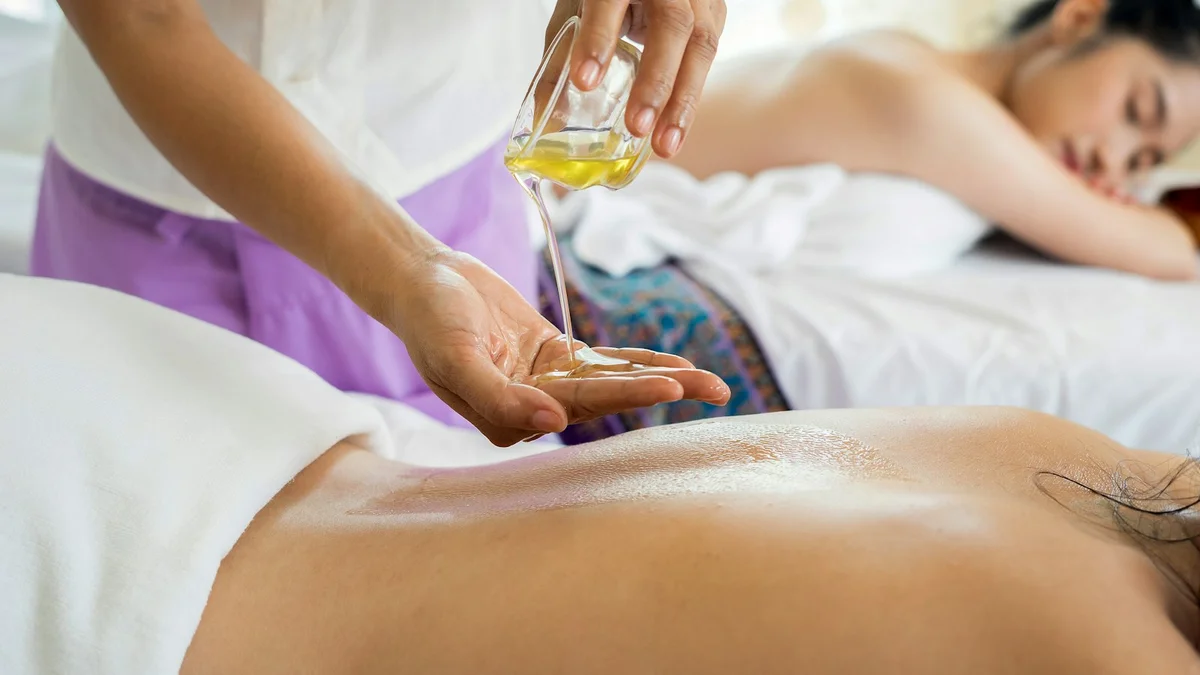 A spa massage with oil being poured onto a person's back, hands working - a Quiet Core Reset guide to Weekly Energy Reset Rituals You Can Actually Do.