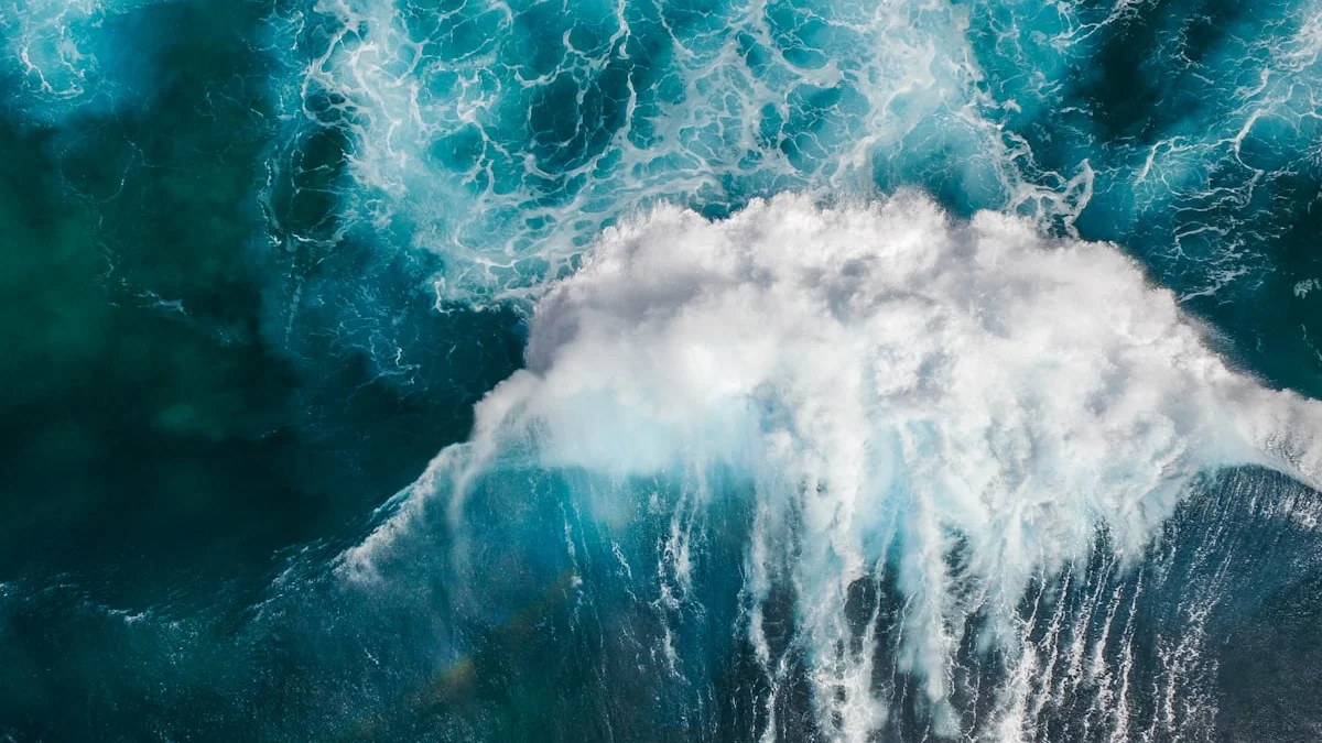 An aerial view of a single wave breaking across deep blue ocean water - a Quiet Core Reset guide to What Science Says About Hustle Culture.