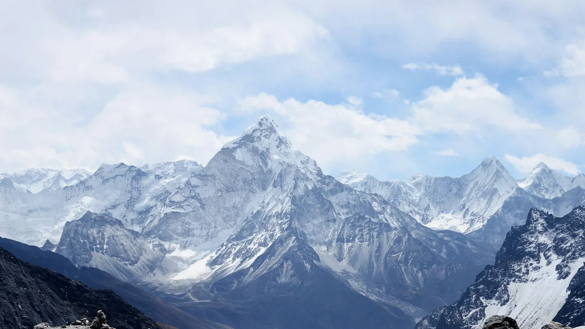 Snow-capped mountain peaks rising against a sky with scattered clouds - a Quiet Core Reset guide to Why Depletion Is So Common Now.
