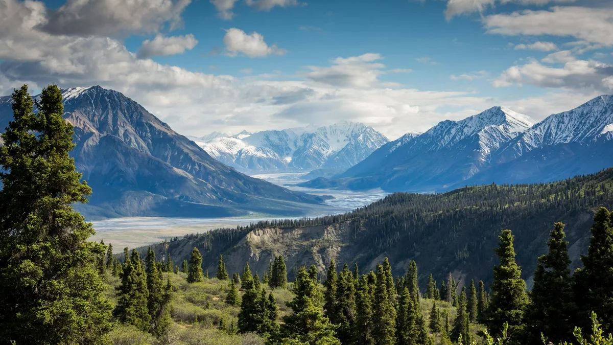 A wide mountain valley with a glacier, forested slopes and a dramatic sky - a Quiet Core Reset guide to Why Burnout Relapse Is So Common Now.