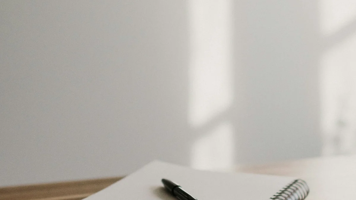 A notebook and pen on a wooden desk in soft window light - a Quiet Core Reset guide to Beginner's Guide to Work Energy.