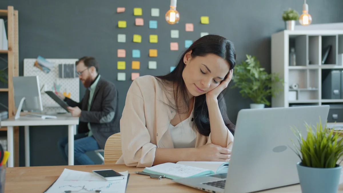 A tired professional resting her head on her hand at a laptop - a Quiet Core Reset guide to 9 Signs Your Work Energy Is Drained (It's Not Just Being Busy).
