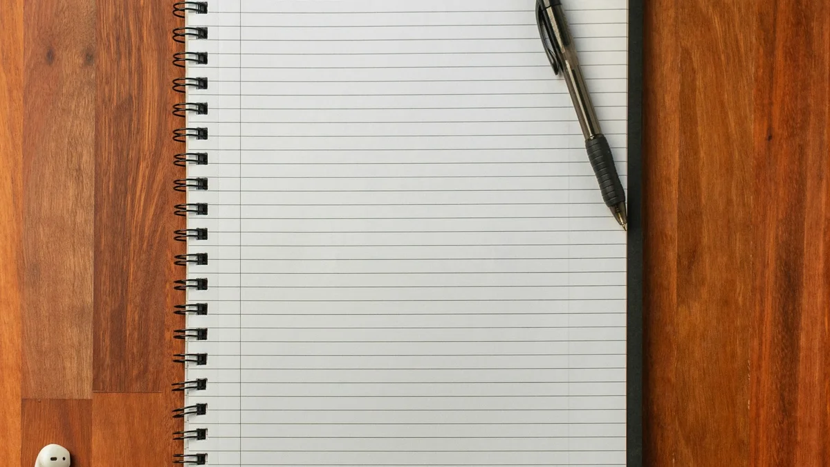 An open notebook and pen beside a laptop and a small plant on a wooden desk - a Quiet Core Reset guide to Work Energy Explained Simply (No Jargon, No Productivity Hacks).
