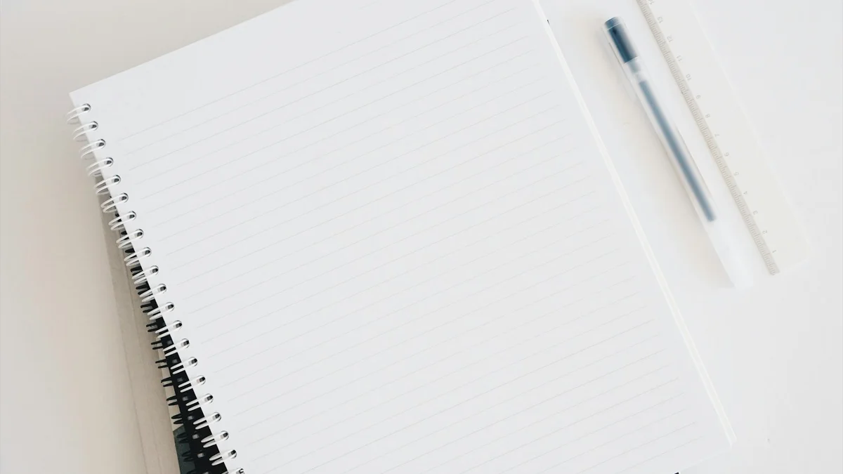 A minimal white desk with a notebook, pen, and keyboard - a Quiet Core Reset guide to 5 Myths About Work Energy (That Keep You Exhausted).
