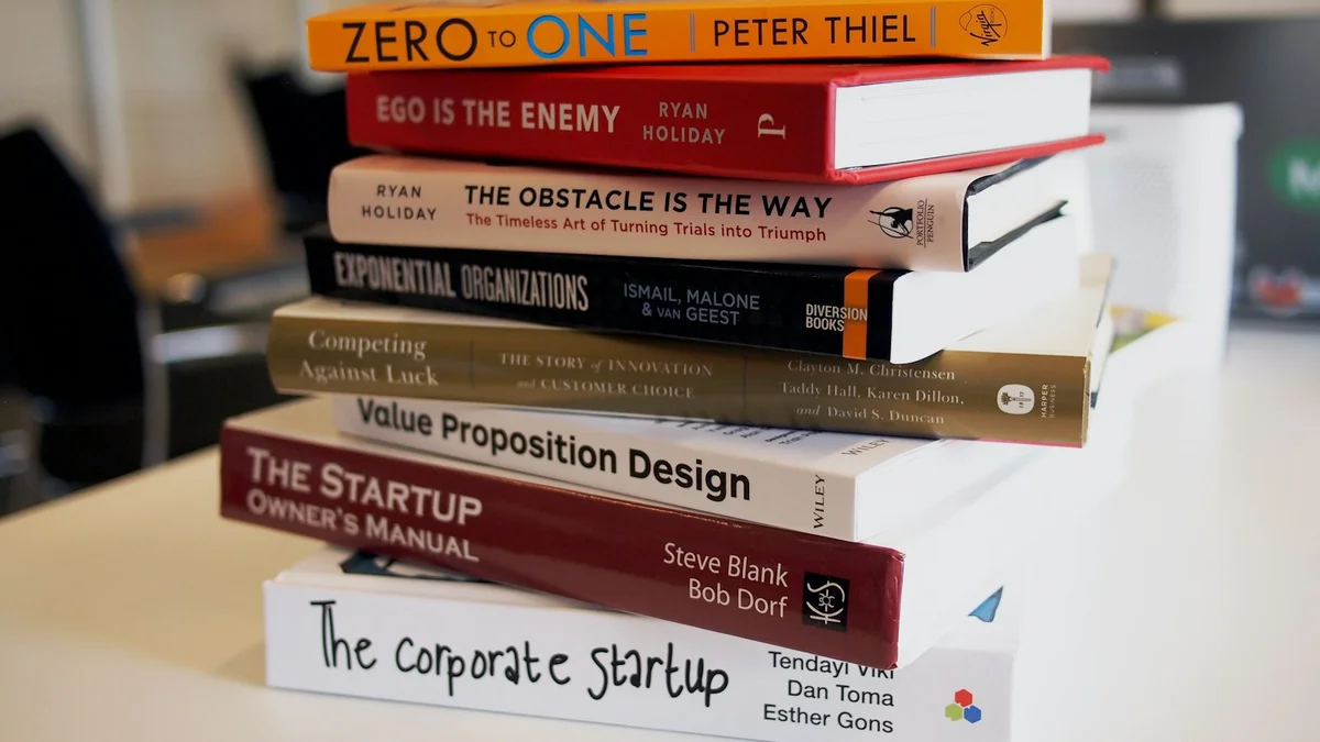 A neat stack of business and strategy books on a table - a Quiet Core Reset guide to Your Worth Is Not Determined by How Much You Give.